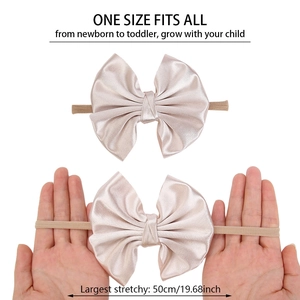 Detail showing high-elasticity baby headband with large satin bow and 50cm stretch