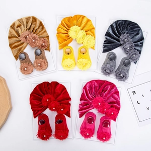 Dettaglio di set cappello e calzini per neonati in velluto con fiori 3D e perle