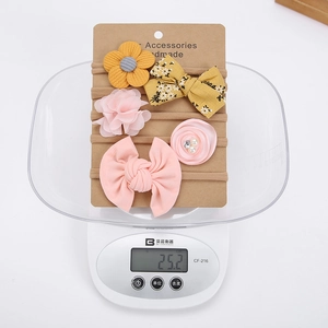 Detailed view of 5-piece baby headband set on a digital scale showing 25.2g weight