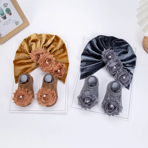 Dettaglio del set cappello a turbante e calzini neonato in velluto con rose 3D