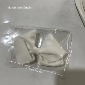 Detailed size view of a large white grosgrain ribbon bow hair clip in its packaging