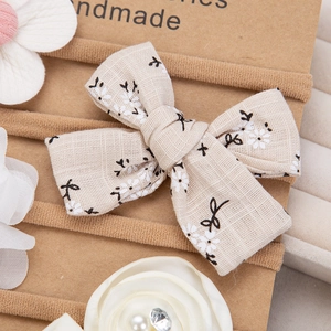 Detailed view of handmade chiffon flowers and linen bows on soft elastic nylon baby headbands