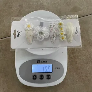 Set of five floral hair clips for women and kids weighing 15.5g on a digital scale
