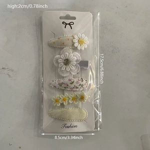 Detailed view of five-piece daisy flower hair clip set for kids on a packaging card