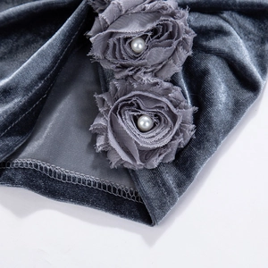 Dettaglio del cappello in velluto grigio scuro per bambini con fiori e perle centrali