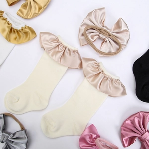 Baby gift set with cream ruffle socks and multi-colored satin bow headbands in soft pastels
