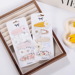 Set of 5 floral embroidery and fabric hair clips for women in a rustic wooden tray