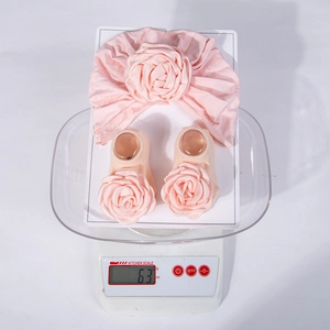 Baby Rosen-Turban-Mütze und Socken Set mit 63 Gramm auf einer Digitalwaage gewogen