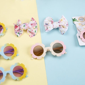 Détail de lunettes de soleil tournesol et pinces à cheveux à nœuds fleuris pour filles