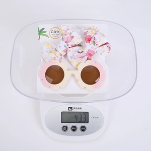 Détail des lunettes de soleil fleurs et pinces à nœuds floraux sur une balance