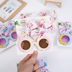 Détail de lunettes de soleil tournesol et barrettes à fleurs sur carte d'affichage