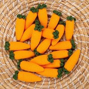 Close-up of handmade crochet carrot ornaments in a natural woven basket for Easter
