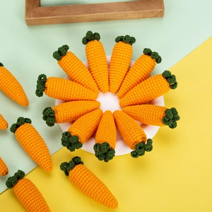 Macro detail of hand-knitted carrot pendants showing vibrant orange crochet texture