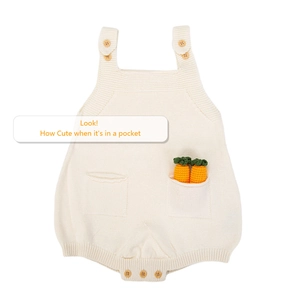Detail of baby knitted cream romper featuring wooden buttons and crochet carrot toys