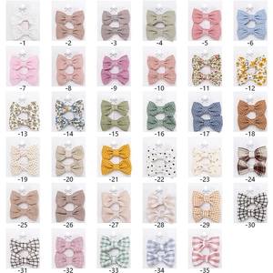 Detailed catalog of 35 assorted floral and plaid fabric bow hair clips for girls