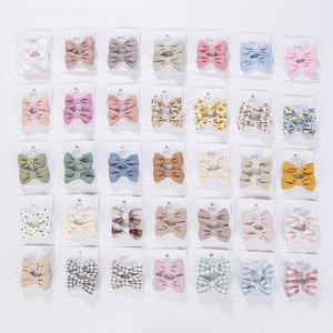 Detailed view of floral and checkered cotton bow hair clips set for young girls