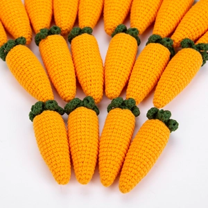 Handmade crochet carrots in vibrant orange and green yarn arranged in a neat fan pattern
