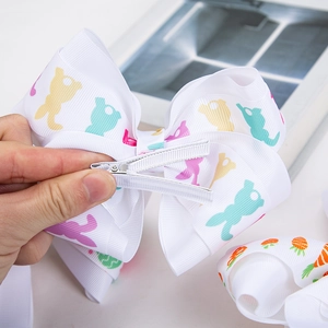 Détail d'un nœud à cheveux de Pâques avec motifs lapins carottes et pince crocodile