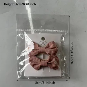 Detail view of pink floral cotton bow hair clips set on display card in packaging
