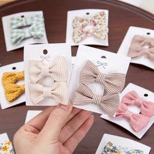 Floral cotton bow hair clips set for girls featuring various patterns on display cards