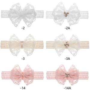 Dettaglio di sei fasce in pizzo per neonati nei colori bianco, beige e rosa con perle