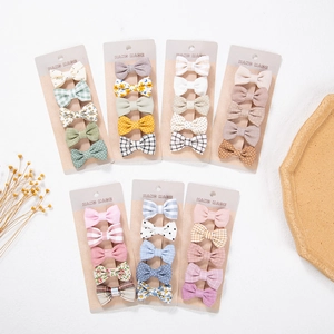 Flat lay of handmade cotton floral bow hair clips set for babies on display cards