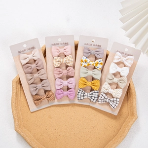 Detailed set of handmade cotton fabric bow hair clips in various patterns on card displays