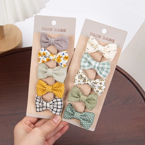 Detailed set of handmade cotton bow hair clips with floral and plaid patterns for kids