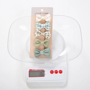 Detailed set of five handmade fabric hair clips including floral and polka dot patterns