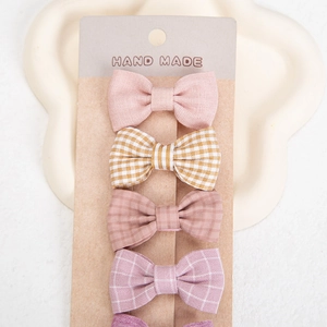 Macro shot of handmade cotton bow hair clips in various patterns on a display card