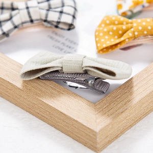 Close-up of cotton bow hair clips with black gingham and polka dot patterns for girls