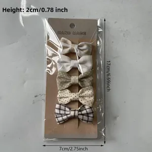 Detail showing five assorted cotton bow hair clips on a 17cm brown card display