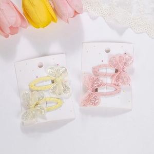 Detail of pink and yellow sequined butterfly hair clips for girls on a display card