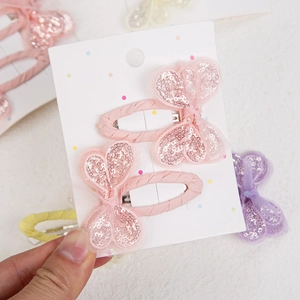 Close-up of pink sequined butterfly BB hair clips with lace trim on a display card