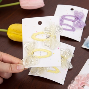 Detailed view of sequin mesh butterfly hair clips in vibrant pink and yellow colors