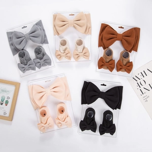 Detail of five earth-toned baby bow headband and ribbed sock sets on white background