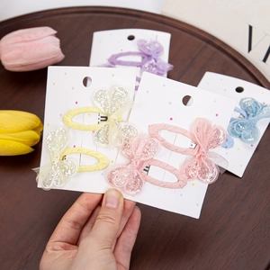 Cute sequined butterfly hair clips for girls in pastel colors on a stylish wood tray