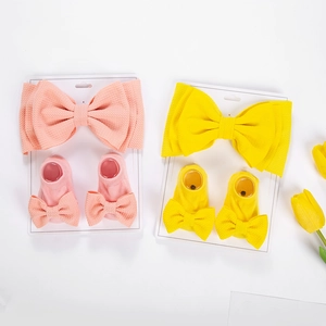 Detailed close-up of baby waffle knit headbands and socks with large bow accents