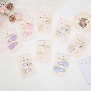 Flat lay of pastel hair clip sets with pearls and bow designs on decorative lace background