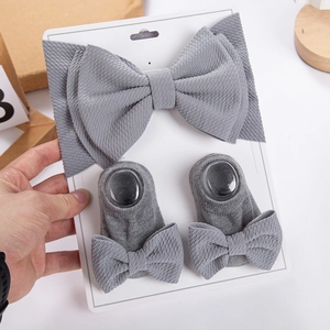 Detail of dark grey ribbed baby headband and bow socks set on white display card