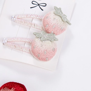Dettaglio del fermaglio per capelli a fragola ricamato con tessuto rosa e perla bianca