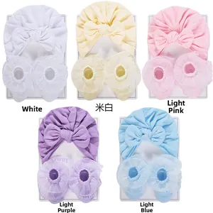 Flat lay of baby turban hat and lace socks sets in white beige pink purple and blue