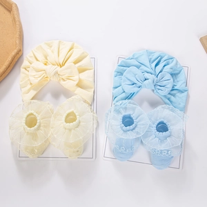 Detail of infant cotton bow headband and lace trim socks set in soft yellow and blue