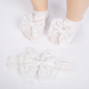 Détails du coffret chaussettes et bandeau bébé avec nœuds en dentelle blanche et tricot ajouré