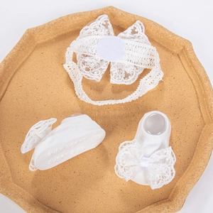Détail du bandeau en dentelle et des chaussettes à nœuds pour bébé sur un plateau