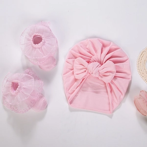 Detailed view of pink baby turban with bow and matching lace trim cotton socks set