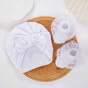 Detail view of baby cotton turban hat with big bow and matching lace trim socks