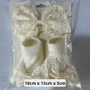 Détail du coffret bandeau et chaussettes bébé en dentelle crème avec emballage 18x15x5 cm