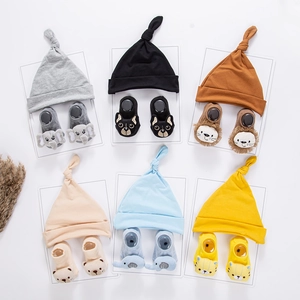 Detail view of multi-color newborn knit hats and matching cartoon animal socks gift sets