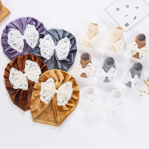 Détail de turbans en velours pour bébé et chaussettes tricotées avec nœuds en dentelle
